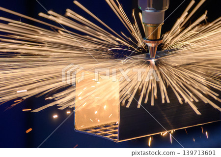 Intense sparkling light from a high-precision fiber laser cutting machine slicing a square stainless steel tube. Intense sparkling light from a high-precision fiber laser cutting machine slicing a square stainless steel tube. 139713601