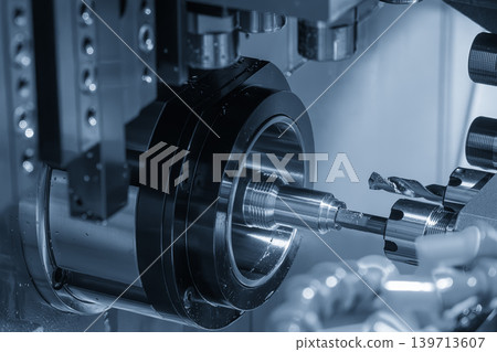 Mass production of high-precision water hose connector parts on a multi-tasking CNC lathe machine in a blue-toned scene. Mass production of high-precision water hose connector parts on a multi-tasking CNC lathe machine in a blue-toned scene. 139713607