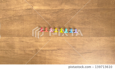 A photo of a wooden table with eight colorful clips lined up. A photo of a wooden table with eight colorful clips lined up. 139713610