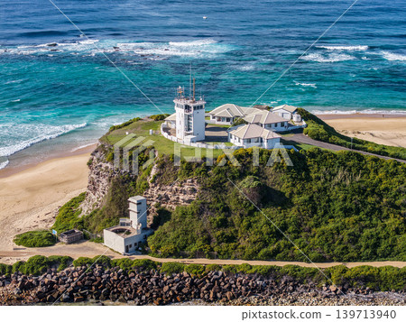 Aerial drone view of Nobbys Beach and the historic Nobbys Lighthouse on the headland at the entrance to Newcastle Harbour. 139713940