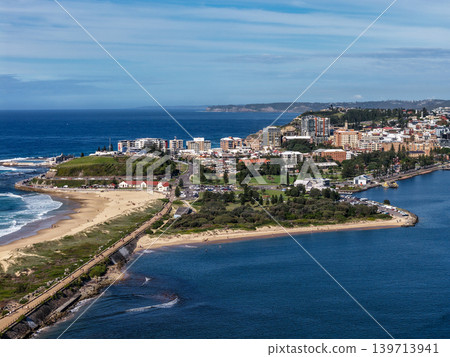 Aerial drone view of Horseshoe Beach and Nobbys Beach with Newcastle city skyline in the background. Aerial drone view of Horseshoe Beach and Nobbys Beach with Newcastle city skyline in the background. 139713941