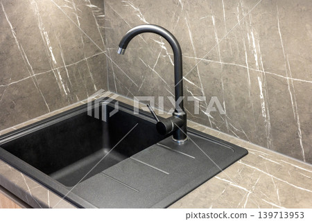 Top view of a sink with a modern black faucet. 139713953