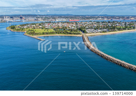 Aerial drone view of Stockton Breakwall extending alongside Stockton Beach with the coastal town of Stockton visible in the distance. 139714000