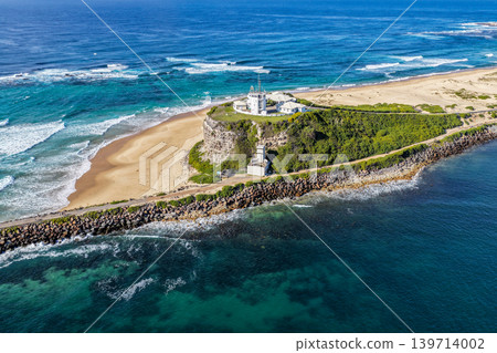 Aerial drone view of Nobbys Lighthouse and sandy Nobbys Beach with Newcastle city skyline and working harbour in the background. Aerial drone view of Nobbys Lighthouse and sandy Nobbys Beach with Newcastle city skyline and working harbour in the background. 139714002