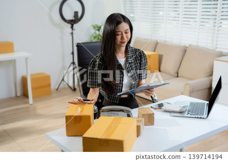 Asian vlogger woman influencer or freelance checking orders from customers. Asian vlogger woman influencer or freelance checking orders from customers. 139714194
