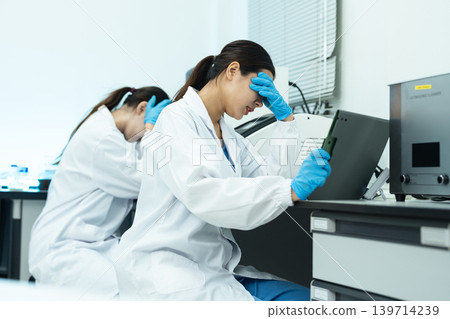 two scientists are under stress from working in research lab. two scientists are under stress from working in research lab. 139714239