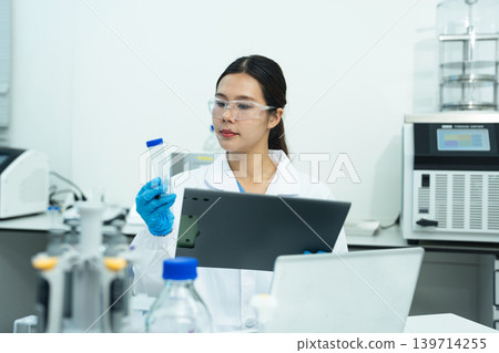 Asian female environmental scientists analyzing water quality samples with centrifuge and petri dish in laboratory. Asian female environmental scientists analyzing water quality samples with centrifuge and petri dish in laboratory. 139714255