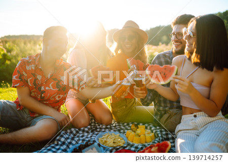 Group of people gathered in garden for picnic. Friends have fun and drink beer. Picnic, friendship. Group of people gathered in garden for picnic. Friends have fun and drink beer. Picnic, friendship. 139714257