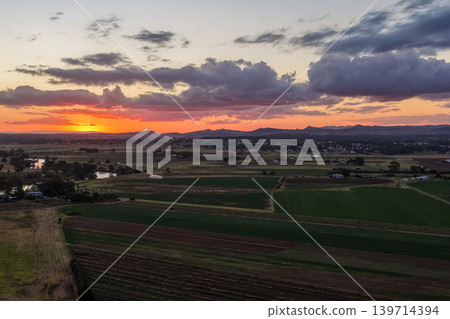 Aerial view of colourful sunset over Morpeth River and surrounding farmland in New South Wales, Australia. Scenic rural landscape showing vibrant sky colours reflecting across water and agricultural Aerial view of colourful sunset over Morpeth River and surrounding farmland in New South Wales, Australia. Scenic rural landscape showing vibrant sky colours reflecting across water and agricultural 139714394