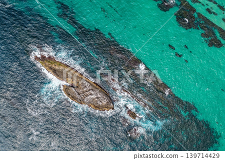 Aerial drone view over McBrides rockpool showing the natural rock formation along a rugged coastline. Ocean water surrounds the rockpool creating a scenic coastal landscape from an elevated Aerial drone view over McBrides rockpool showing the natural rock formation along a rugged coastline. Ocean water surrounds the rockpool creating a scenic coastal landscape from an elevated 139714429