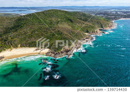 Aerial drone view over McBrides Beach showing the surrounding coastal landscape with ocean water, sandy shoreline and natural scenery. The elevated perspective highlights the rugged coastline and Aerial drone view over McBrides Beach showing the surrounding coastal landscape with ocean water, sandy shoreline and natural scenery. The elevated perspective highlights the rugged coastline and 139714430