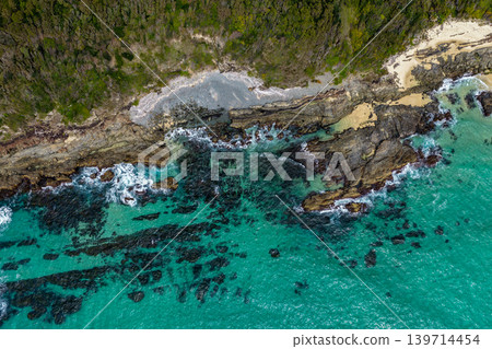 Aerial drone view over McBrides rockpool showing the natural rock formation along a rugged coastline. Ocean water surrounds the rockpool creating a scenic coastal landscape from an elevated 139714454