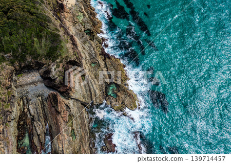Aerial drone view over McBrides rockpool showing the natural rock formation along a rugged coastline. Ocean water surrounds the rockpool creating a scenic coastal landscape from an elevated Aerial drone view over McBrides rockpool showing the natural rock formation along a rugged coastline. Ocean water surrounds the rockpool creating a scenic coastal landscape from an elevated 139714457