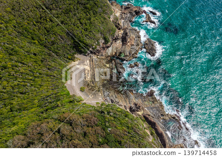 Aerial drone view over McBrides rockpool showing the natural rock formation along a rugged coastline. Ocean water surrounds the rockpool creating a scenic coastal landscape from an elevated Aerial drone view over McBrides rockpool showing the natural rock formation along a rugged coastline. Ocean water surrounds the rockpool creating a scenic coastal landscape from an elevated 139714458