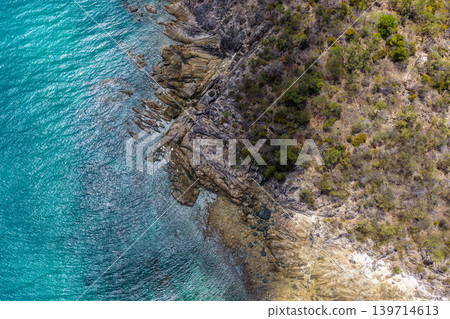Aerial view over Hydeaway Bay in QLD Australia. Drone photograph captures the tropical coastline, clear ocean water and scenic waterfront landscape from above. Aerial view over Hydeaway Bay in QLD Australia. Drone photograph captures the tropical coastline, clear ocean water and scenic waterfront landscape from above. 139714613