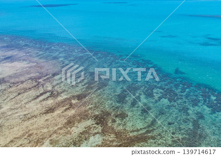 Aerial view over Hydeaway Bay in QLD Australia. Drone photograph captures the tropical coastline, clear ocean water and scenic waterfront landscape from above. 139714617