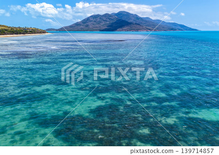 Aerial view over Hydeaway Bay in QLD Australia. Drone photograph captures the tropical coastline, clear ocean water and scenic waterfront landscape from above. Natural Australian coastal environment 139714857