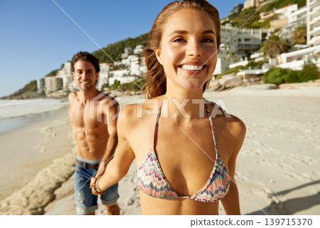 Face, smile and leading with couple at beach in summer together for travel, vacation or holiday. Love, trust or romance with happy young man and woman on coast by sea or ocean for adventure in Hawaii Face, smile and leading with couple at beach in summer together for travel, vacation or holiday. Love, trust or romance with happy young man and woman on coast by sea or ocean for adventure in Hawaii 139715370