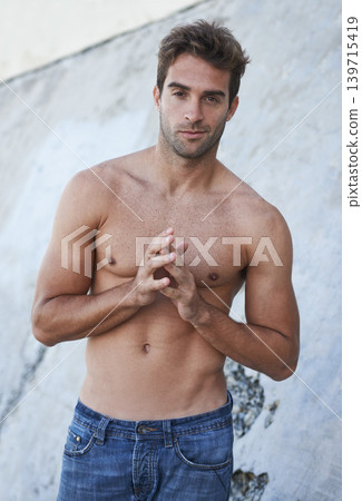 Man, portrait and fitness body with abs, stomach and wellness outdoor by a wall. Summer, workout and fashion of a male person from Brazil with strong arms, torso and topless with confidence and smirk Man, portrait and fitness body with abs, stomach and wellness outdoor by a wall. Summer, workout and fashion of a male person from Brazil with strong arms, torso and topless with confidence and smirk 139715419