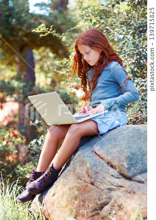 Young girl, forest and laptop on rock for internet, break and connection on holiday in woods for travel tips. Child, red hair and computer on boulder for online research, camping and relax by trees 139715825
