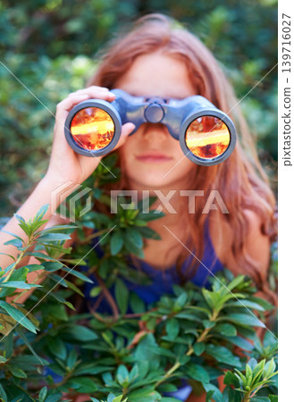 Girl, kid with binoculars and search in nature for learning and fun, forest and adventure at summer camp. Young camper, leaves and explore environment outdoor in bush with hiking and discovery Girl, kid with binoculars and search in nature for learning and fun, forest and adventure at summer camp. Young camper, leaves and explore environment outdoor in bush with hiking and discovery 139716027
