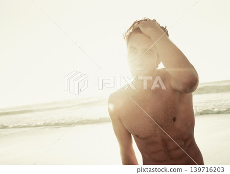 Man, shirtless and relaxing on beach at sunset, confidence and tourist at sea on summer holiday. Male person, lens flare and outdoor adventure for fun, calm ocean and peaceful environment in nature Man, shirtless and relaxing on beach at sunset, confidence and tourist at sea on summer holiday. Male person, lens flare and outdoor adventure for fun, calm ocean and peaceful environment in nature 139716203
