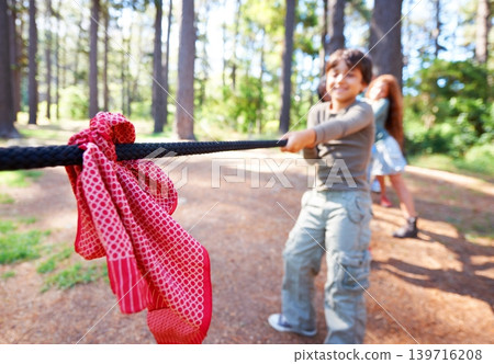 Kids, game and tug of war in forest at summer camp and holiday with travel and energy outdoor. Children with rope, adventure and team building with fun contest, playful and young friends in a park 139716208