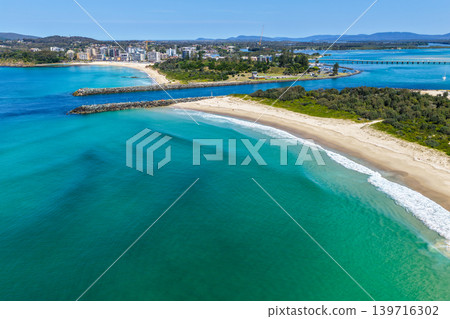 Aerial view of Nine Mile Beach and the Forster Tuncurry breakwalls in NSW Australia. Drone photograph captures the expansive sandy shoreline, ocean coastline Aerial view of Nine Mile Beach and the Forster Tuncurry breakwalls in NSW Australia. Drone photograph captures the expansive sandy shoreline, ocean coastline 139716302