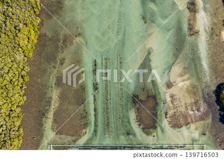 Aerial downward view of clear waters and natural sand patterns in the Coolongolook River in Tuncurry NSW Australia. Drone photograph captures the shallow estuary, textured sand formations Aerial downward view of clear waters and natural sand patterns in the Coolongolook River in Tuncurry NSW Australia. Drone photograph captures the shallow estuary, textured sand formations 139716503