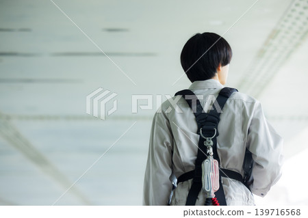 Workers wearing full body harnesses Workers wearing full body harnesses 139716568