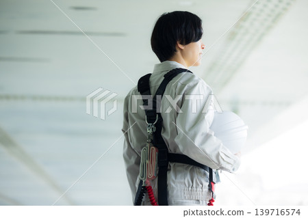 Workers wearing full body harnesses Workers wearing full body harnesses 139716574