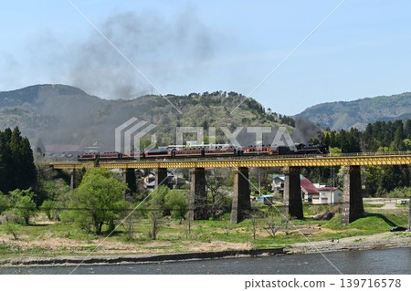 The Ban'etsu Monogatari train crosses the Ichinotogawa Bridge on the Ban'etsu West Line, with the snow-capped Iide Mountain Range in the background. The Ban'etsu Monogatari train crosses the Ichinotogawa Bridge on the Ban'etsu West Line, with the snow-capped Iide Mountain Range in the background. 139716578