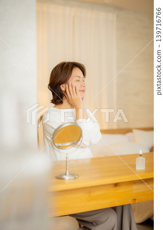 一位女性夜裡在臥室裡擔心自己的皮膚狀況。 一位女性夜裡在臥室裡擔心自己的皮膚狀況。 139716766