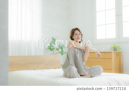 A woman sitting on a bed A woman sitting on a bed 139717218