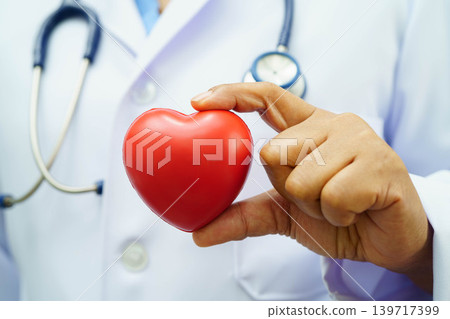 Asian woman doctor holding red heart for health in hospital. Asian woman doctor holding red heart for health in hospital. 139717399