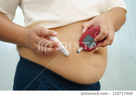 Asian woman injecting herself diabetes injecting insulin in stomach at home. Asian woman injecting herself diabetes injecting insulin in stomach at home. 139717400