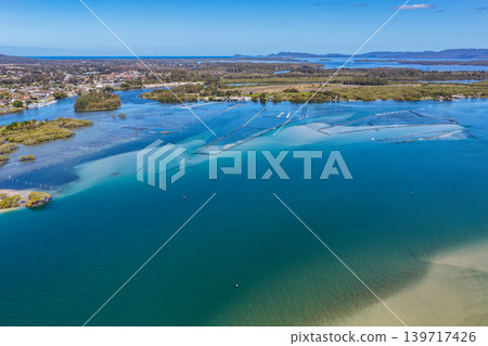 Aerial view of Wallis Lake in Forster NSW Australia. Drone photograph captures the expansive lake system, clear waterways and surrounding coastal landscape Aerial view of Wallis Lake in Forster NSW Australia. Drone photograph captures the expansive lake system, clear waterways and surrounding coastal landscape 139717426