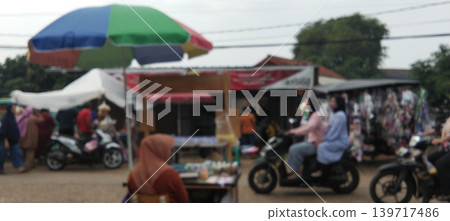 The atmosphere of a traditional market with traders and motorcyclists mingling. 139717486