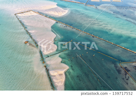 Aerial view of an oyster lease in the clear shallow waters of Wallis Lake in Forster NSW Australia. Drone photograph captures oyster farming infrastructure, transparent waterways and natural estuary Aerial view of an oyster lease in the clear shallow waters of Wallis Lake in Forster NSW Australia. Drone photograph captures oyster farming infrastructure, transparent waterways and natural estuary 139717552