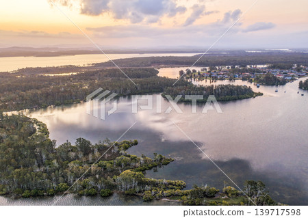 Aerial view of sunset over islands and the Coolongolook River in Tuncurry NSW Australia. Drone photograph captures calm waterways, estuary islands and colourful evening reflections 139717598