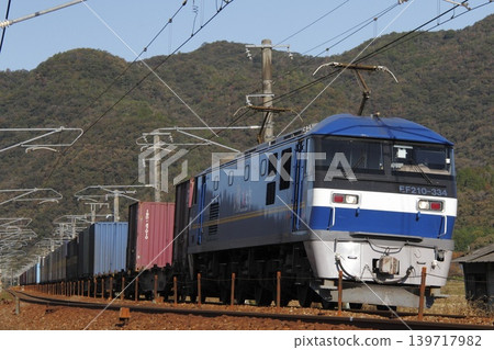 一列由EF210型機車牽引的貨運列車正在山陽本線上行駛。 一列由EF210型機車牽引的貨運列車正在山陽本線上行駛。 139717982