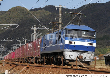 一列由EF210型機車牽引的貨運列車正在山陽本線上行駛。 一列由EF210型機車牽引的貨運列車正在山陽本線上行駛。 139717987