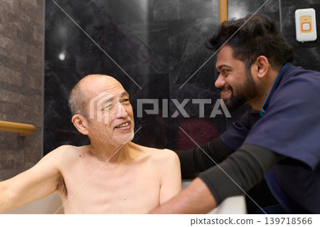 Foreign caregivers assisting Japanese seniors with bathing. Foreign caregivers assisting Japanese seniors with bathing. 139718566