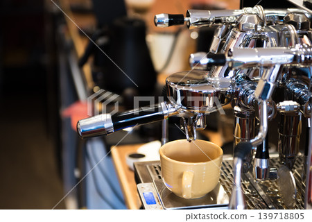 Working at a cafe, using an espresso machine. 139718805