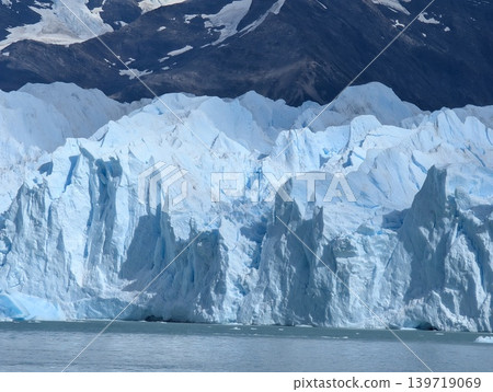 Detailed view of blue glacial ice wall and mountain ridges Detailed view of blue glacial ice wall and mountain ridges 139719069