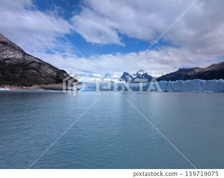 Wide landscape of Argentino Lake with distant glacier and mountains under cloudy sky Wide landscape of Argentino Lake with distant glacier and mountains under cloudy sky 139719075