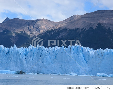 Close view of massive Perito Moreno glacier ice wall with mountain background 139719079