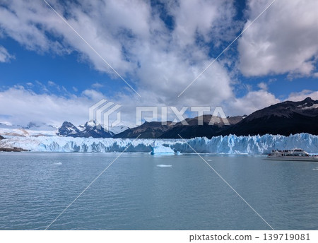 Tourist boat near Perito Moreno glacier under blue sky with clouds Tourist boat near Perito Moreno glacier under blue sky with clouds 139719081