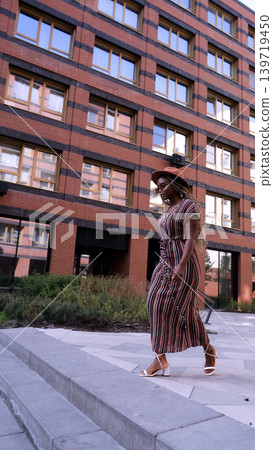 Young woman resting and relaxing while walking on city street in new eco-friendly residential complex. Relaxation and stress-free concept. Young woman resting and relaxing while walking on city street in new eco-friendly residential complex. Relaxation and stress-free concept. 139719450