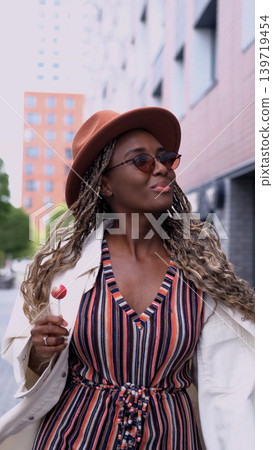 Young woman resting and relaxing while walking on city street in new eco-friendly residential complex. Relaxation and stress-free concept. Young woman resting and relaxing while walking on city street in new eco-friendly residential complex. Relaxation and stress-free concept. 139719454